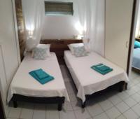 two beds in a room with towels on them at Villa Kannel in Petit-Bourg