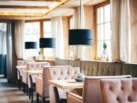 Un comedor con mesas y sillas y ventanas. en Boutiquehotel Blaue Burg Falkenstein, en Pfronten