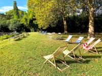 a row of lawn chairs sitting in the grass at Le Mas de Patrice in Quissac