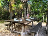 a wooden picnic table with a bench and an arbor at Le Mas de Patrice in Quissac