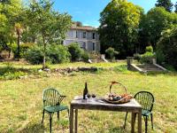 a table with a basket of fruit and a bottle of wine at Le Mas de Patrice in Quissac