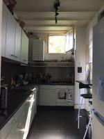 a kitchen with white cabinets and a window at TOPFLOOR Les Terrasses in Dieppe