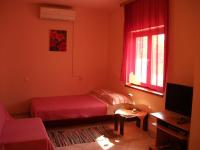 a small bedroom with a bed and a window at Apartment Dusko - free parking in Gornji Karin
