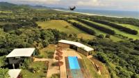 un avión sobrevolando una casa con piscina en La Colina Pura Vista, en Bejuco