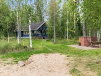 a blue house in the woods with a picnic table at Holiday Home Tiira by Interhome in Himahuuha