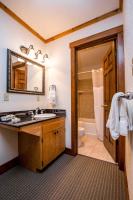 a bathroom with a sink and a toilet and a mirror at Kandahar Lodge at Whitefish Mountain Resort in Whitefish