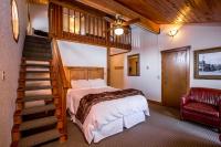 a bedroom with a bed and a staircase with a stair case at Kandahar Lodge at Whitefish Mountain Resort in Whitefish