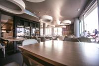 a restaurant with tables and chairs and people in the background at Mosella Suite Hotel in Sottomarina