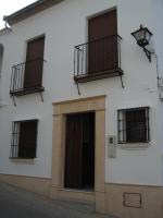 a white building with three windows and a door at El Palacete in Setenil