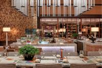 Un comedor con mesas y sillas y un restaurante. en The ERAVATI Sule Grand Yangon, en Yangón