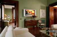 a living room with a couch and a tv on the wall at Villa Spalletti Trivelli - Small Luxury Hotels of the World in Rome