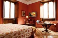 a bedroom with red walls and a bed and a table at Villa Spalletti Trivelli - Small Luxury Hotels of the World in Rome