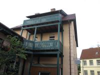 a building with a balcony on the side of it at Pension zum Yachthafen in Waren