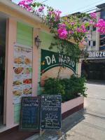 een restaurant met een bord aan de zijkant van een gebouw bij Da Mario Hotel & Restaurant in Karon Beach
