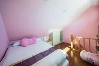 a bedroom with a bed with a pink pillow on it at Julie&#39;s Garden, Cingjing - Fon Chin Homestay in Ren&#39;ai