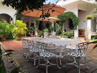 uma mesa e cadeiras com um guarda-sol em um pátio em NAH SAM CHAK La Casa Rosada em Tapachula