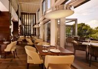 een restaurant met tafels en stoelen en een groot raam bij Metropol Palace, Belgrade in Belgrado