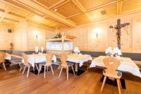 comedor con mesas, sillas y paredes de madera en Hotel Asterbel, en Braies