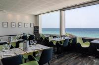 コンカルノーにあるレ サーブルブランのテーブルと椅子があり、海が見えるレストラン