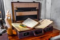 a suitcase with books and a clock on a table at H&amp; Jiufen Ore Inn in Jiufen