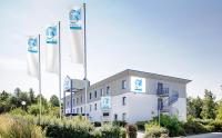 un edificio blanco con banderas delante en T3 Budget Zwickau, en Zwickau