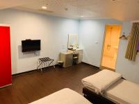 a room with two beds and a flat screen tv at EasyInn Hotel &amp; Hostel in Tainan
