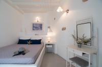 a white bedroom with a bed and a desk at Krotiri Bay -adults only in Parikia