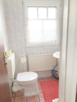 a bathroom with a white toilet and a window at Pension Huber in Klosterneuburg