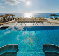 Una piscina con sillas y el océano al fondo. en Royal Sun Resort, en Acantilado de los Gigantes