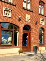ein rotes Backsteingebäude mit einer großen Tür und Fenstern in der Unterkunft Willa Biala Lilia Old Town in Danzig