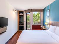 a hotel room with a bed and a tv at Ibis Phuket Patong in Patong Beach