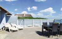 a patio with a table and chairs and a white fence at Lovely Home In Hvide Sande With Kitchen in Havrvig