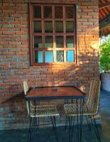 a wooden table and two chairs in front of a brick wall at Village Bali in Uluwatu