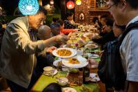a group of people sitting at a long table eating food at Hotel Green Horizon in Kathmandu