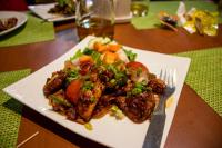 a plate of food with chicken and vegetables on a table at Hotel Green Horizon in Kathmandu