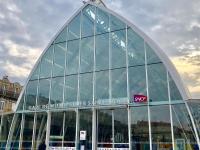 a glass building with a sign in front of it at Hôtel Colisée-Verdun Centre Gare Saint-Roch in Montpellier
