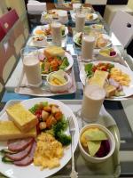 a table with plates of food and glasses of milk at Sunny Sun B&amp;B in Taitung City