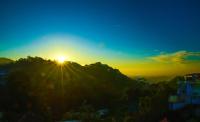 una puesta de sol en la cima de una montaña con la puesta de sol en Senasuma Homestay, en Ella