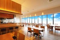 a restaurant with tables and chairs and large windows at Henn na Resort & Spa Kansai Airport - former Henn na Hotel Kansai Airport in Izumi-Sano