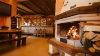 a fireplace in a room with a table and a bar at Hotel Kaķītis in Sigulda