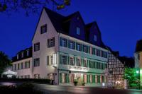 un gran edificio blanco con ventanas verdes por la noche en Hotel Nassauer Hof, en Limburg an der Lahn