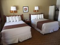 ein Hotelzimmer mit zwei Betten und zwei Lampen in der Unterkunft Thunderbird Lodge in Chinle
