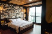 a bedroom with a large bed and a stone wall at Yong Guan in Yuchi