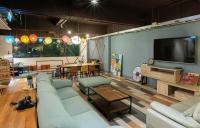 a living room with couches and a flat screen tv at Uno Backpackers Inn in Kaohsiung