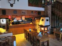 Un restaurante con mesas y sillas y un bar. en Rodinný "Hotel U Můstků", en Desná