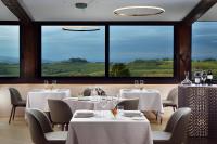 a restaurant with white tables and chairs and large windows at Borgobrufa Spa Resort Adults Only in Brufa