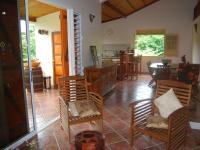 Una sala de estar con sillas y un comedor. en RESIDENCE LA TAUPINE MANDARINE, en Le Diamant