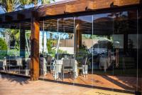 キアにあるホテル アクアドゥルチのガラスの壁とテーブルと椅子のあるダイニングエリア