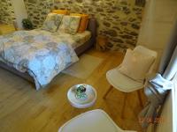 a bedroom with a bed and a table and chairs at L étable au naturel in Mauriac