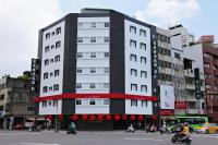 a large white building with people riding motorcycles on a street at Ai Lai Fashion Hotel in Taichung